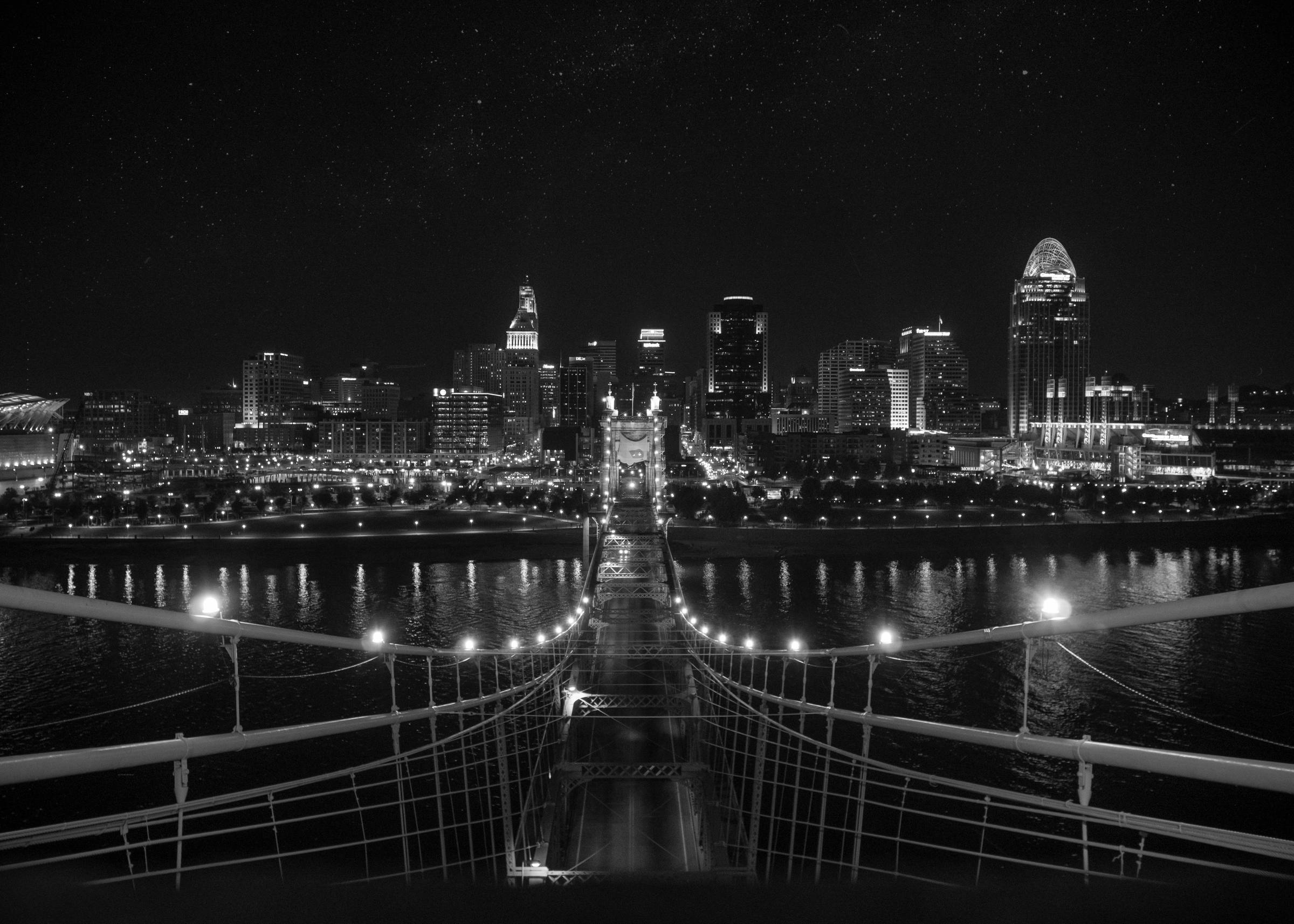 The Cincinnati skyline at night, seen from the Roebling Suspension Bridge.